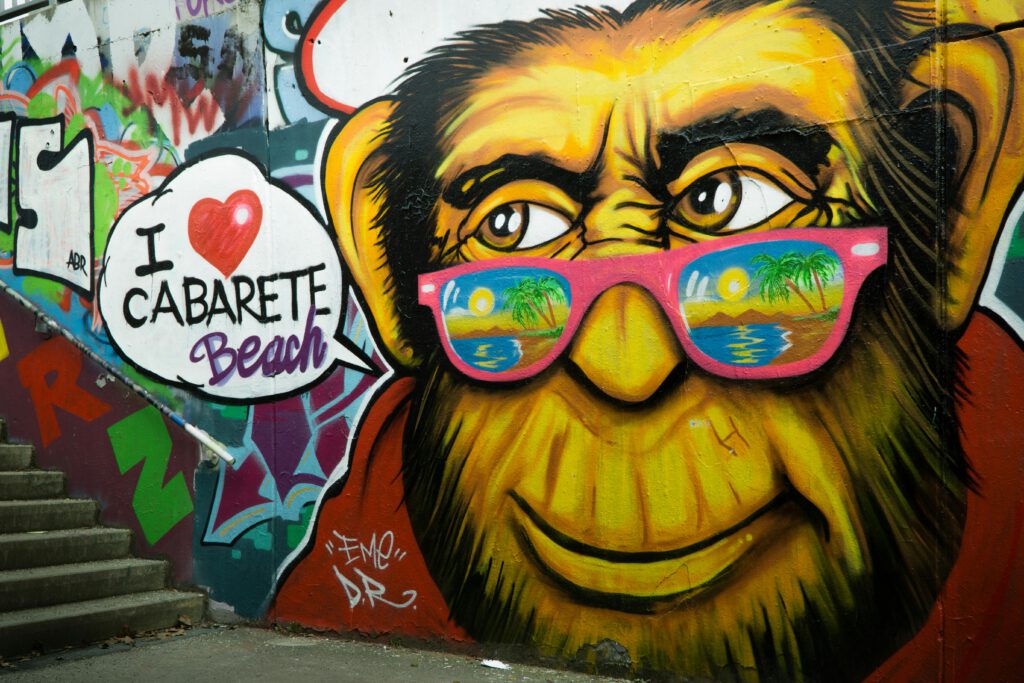 Urlaub Dominikanische Republik. Graffiti-Kunst mit stilisiertem Affen und „I ❤️ Cabarete Beach“ – Ausdruck der lebendigen Surf- und Kulturszene in der Dominikanischen Republik.