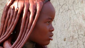 Kind mit traditionellen Zöpfen vor Wand – Familienurlaub in Namibia mit Safari und Kultur