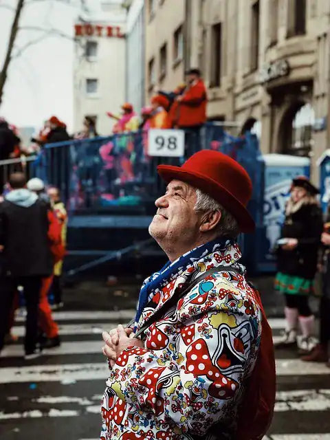 Karneval in Köln mit bunt verkleideten Menschen auf der Straße vor städtischer Kulisse