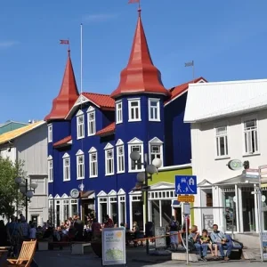Akureyri Straßenszene in Akureyri mit farbenfrohen Gebäuden, Cafébesuchern und klarblauem Himmel