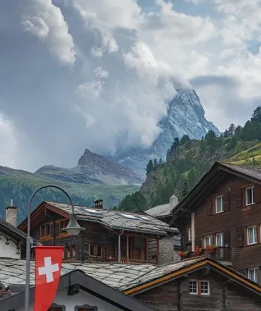 Matterhorn bei Zermatt mit traditionellen Chalets und Schweizer Flagge