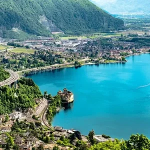 Genfersee Genfersee mit Alpenkulisse und Uferstadt bei Sonnenschein