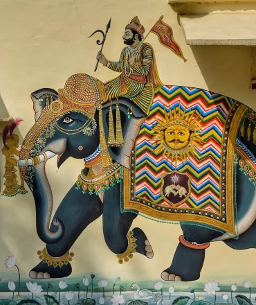Indien Urlaub. Indisches Wandgemälde mit König auf geschmücktem Elefanten – traditionelle Kunst in leuchtenden Farben
