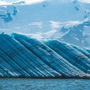 Jökulsárlón Eisberg in der Gletscherlagune Jökulsárlón mit schneebedeckten Bergen im Hintergrund