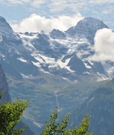 Jungfraujoch mit schneebedeckten Gipfeln und grüner Waldlandschaft