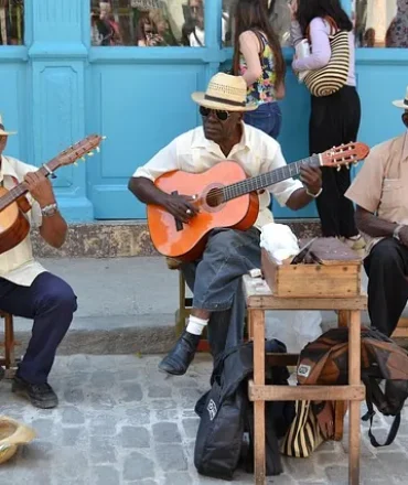 Straßenmusiker vor farbenfroher Fassade mit Gitarren und Percussion – Symbol für kubanische Lebensfreude und kulturelle Vielfalt in Havanna.