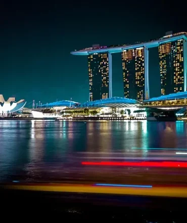 Singapur bei Nacht mit Marina Bay Sands, ArtScience Museum und beleuchtetem Singapore Flyer am Wasser