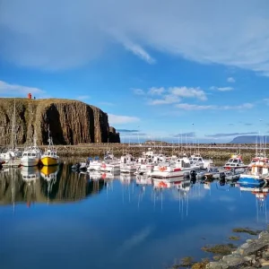 Snæfellsnes Hafen in Snæfellsnes mit kleinen Booten, spiegelndem Wasser und Basaltklippen im Hintergrund