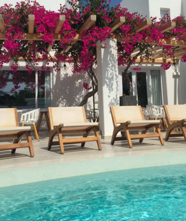 Poolbereich mit weißen Möbeln und Bougainvillea auf den Kanaren oder Balearen