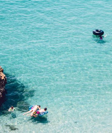 Urlaub Spanien. Zwei Paddleboarder auf türkisblauem Meer vor Spaniens Küste